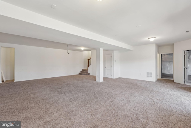 basement featuring visible vents, stairs, and carpet floors