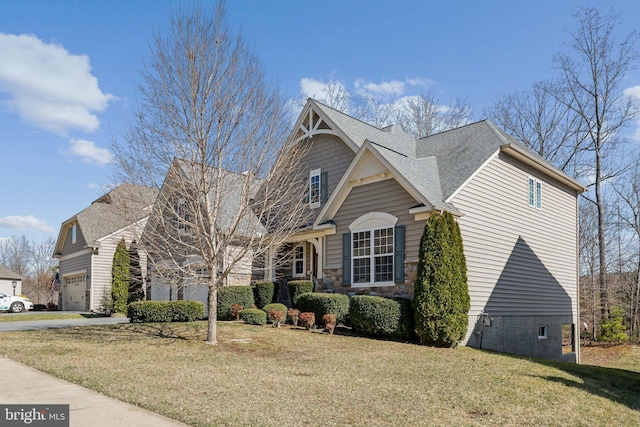 view of front of property with a front yard, driveway, roof with shingles, stone siding, and a garage