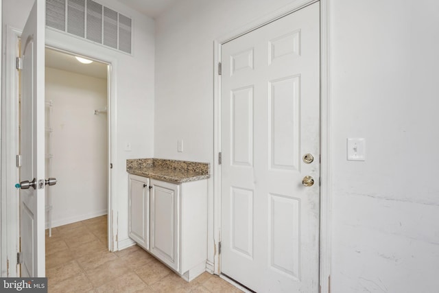 interior space featuring vanity, baseboards, and visible vents