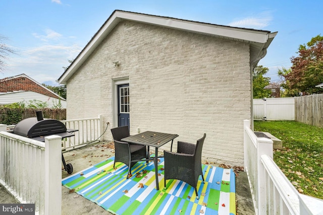 rear view of property with brick siding and a fenced backyard