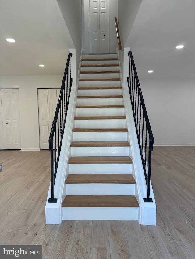 stairs featuring recessed lighting, wood finished floors, and baseboards