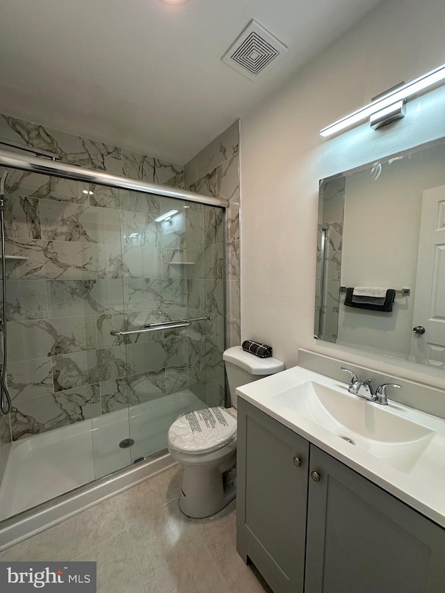 full bath featuring vanity, toilet, visible vents, and a marble finish shower