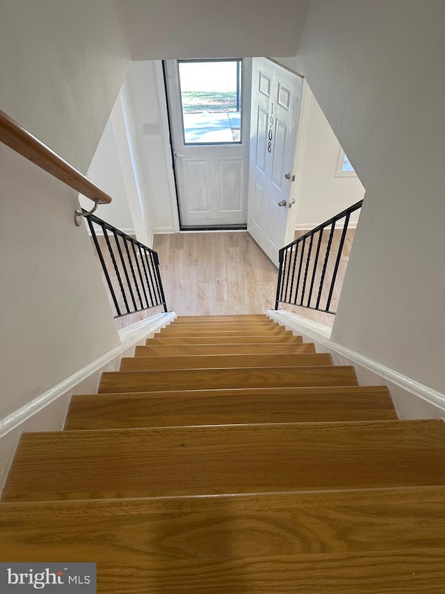 stairway with baseboards and wood finished floors