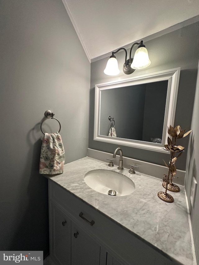 bathroom featuring vanity, lofted ceiling, and ornamental molding