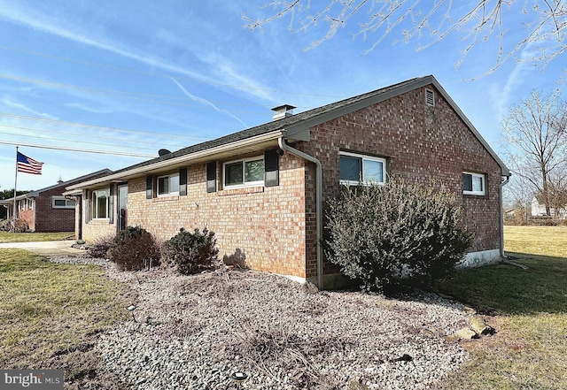 view of side of property with a yard and brick siding