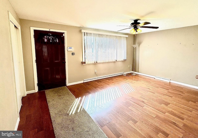 entryway with visible vents, a baseboard heating unit, baseboards, and wood finished floors