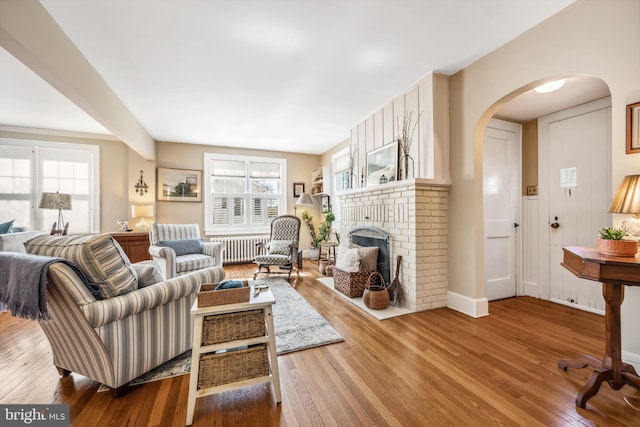 901 S Talbot, Saint Michaels, MD 21663 - living room featuring arched walkways, wood finished floors, a fireplace, and a healthy amount of sunlight