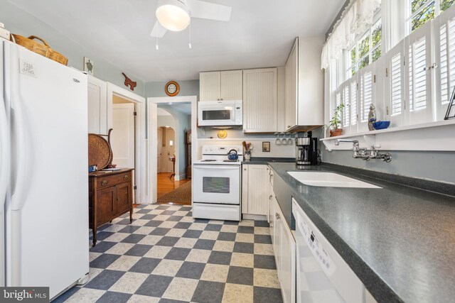 901 S Talbot, Saint Michaels, MD 21663 - kitchen with arched walkways, a sink, dark countertops, a ceiling fan, and white appliances