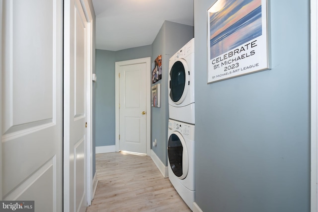 901 S Talbot, Saint Michaels, MD 21663 - clothes washing area featuring baseboards, light wood-type flooring, stacked washing maching and dryer, and laundry area