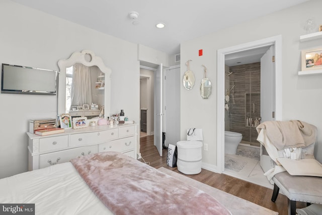 bedroom with recessed lighting, connected bathroom, baseboards, and wood finished floors