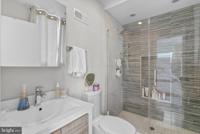 full bathroom featuring visible vents, a stall shower, toilet, and vanity