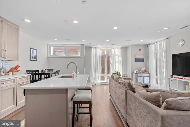 kitchen featuring a sink, a kitchen bar, light wood-type flooring, and open floor plan