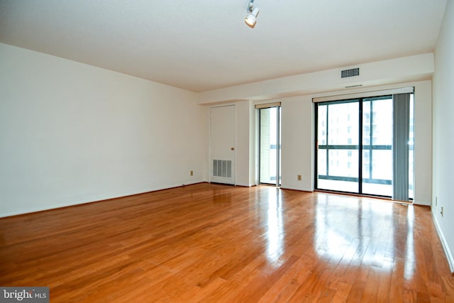 unfurnished room featuring light wood-style floors and visible vents