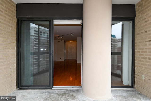 view of exterior entry featuring brick siding