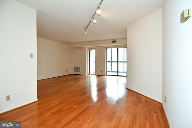 empty room with visible vents, baseboards, and light wood-style floors