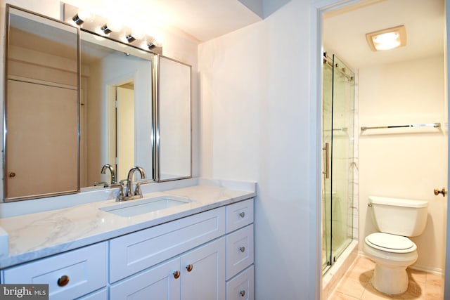 bathroom with an enclosed shower, toilet, vanity, and tile patterned flooring