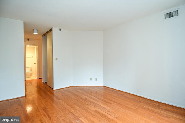 spare room with visible vents, baseboards, and light wood-style floors