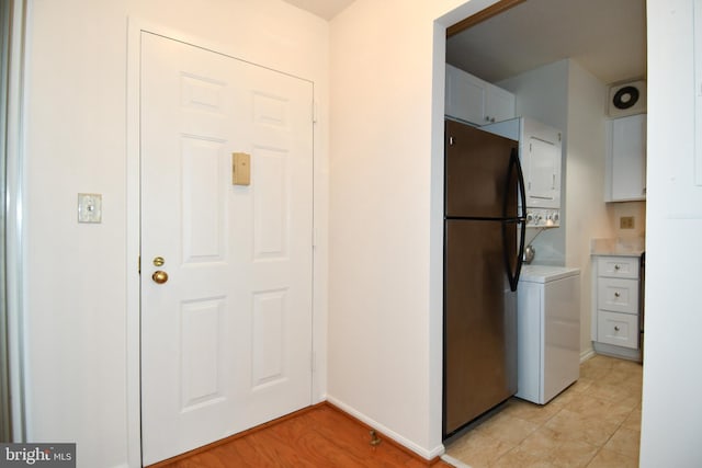 kitchen with baseboards, stacked washer and dryer, light countertops, and freestanding refrigerator