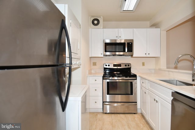 kitchen featuring white cabinets, appliances with stainless steel finishes, and a sink