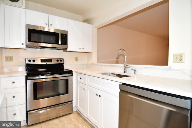 kitchen featuring a sink, light stone countertops, white cabinetry, and stainless steel appliances