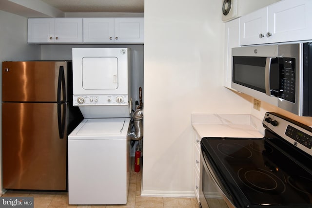 laundry area with laundry area, light tile patterned floors, and stacked washer and clothes dryer