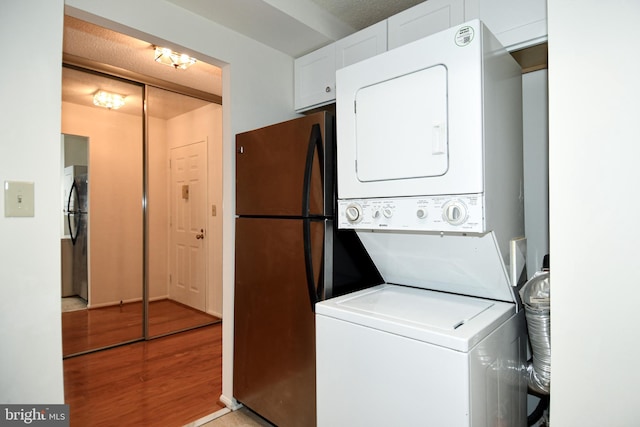 laundry room with light wood-style floors and stacked washer and clothes dryer