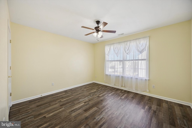 spare room featuring visible vents, baseboards, dark wood-style floors, and a ceiling fan