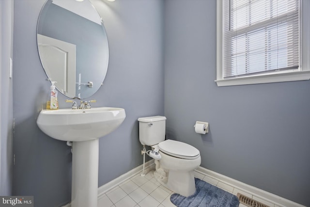 bathroom featuring visible vents, a healthy amount of sunlight, toilet, and baseboards