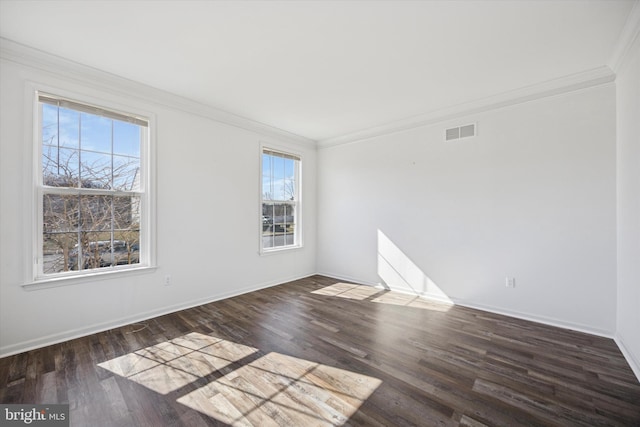 spare room with visible vents, baseboards, wood finished floors, and ornamental molding