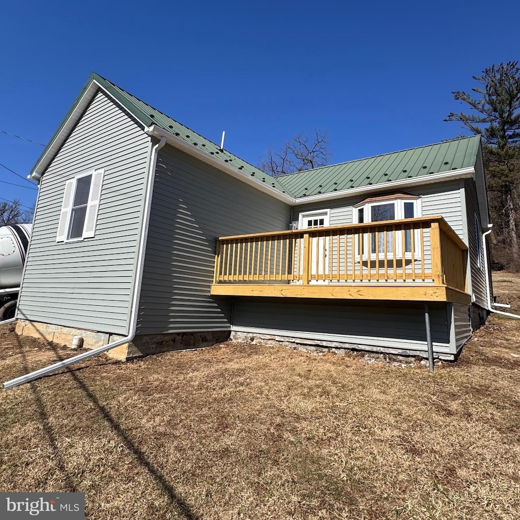 rear view of property with metal roof and a deck