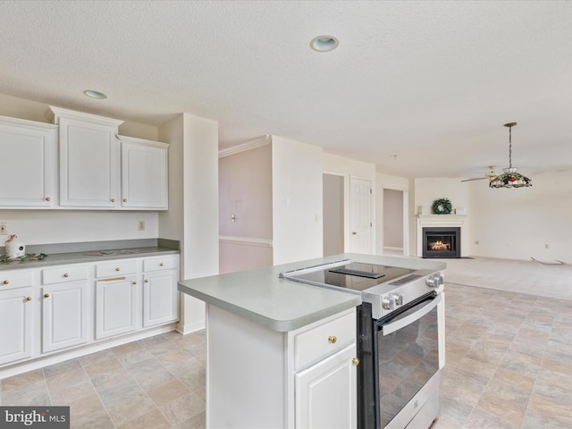 kitchen featuring a warm lit fireplace, range with electric cooktop, white cabinets, open floor plan, and a center island