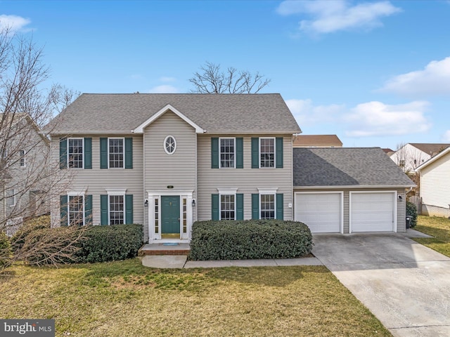 colonial home with a front lawn, concrete driveway, an attached garage, and a shingled roof