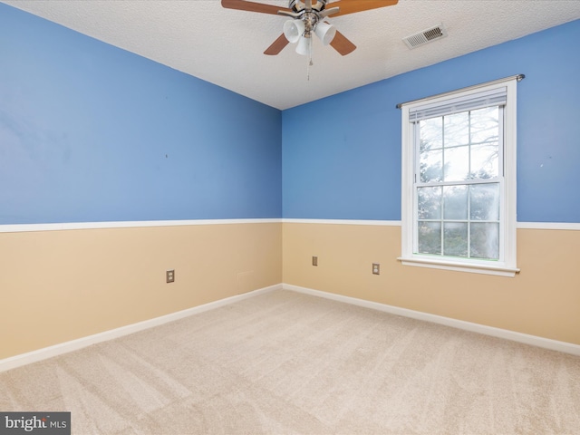 spare room featuring visible vents, baseboards, ceiling fan, and carpet floors