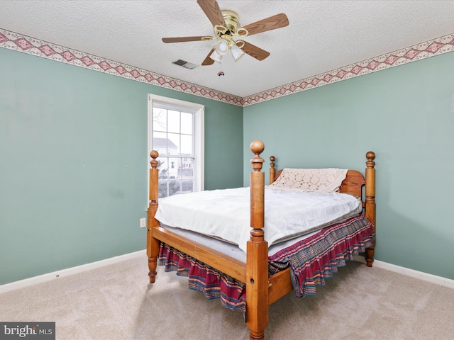 bedroom with a textured ceiling, carpet, visible vents, and baseboards