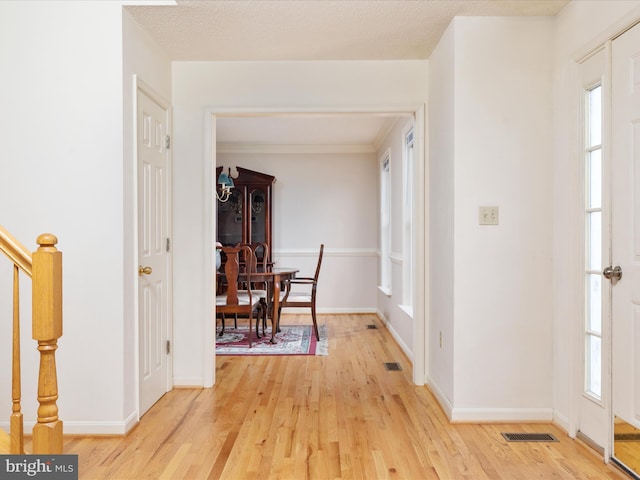 interior space featuring visible vents, light wood-type flooring, and baseboards