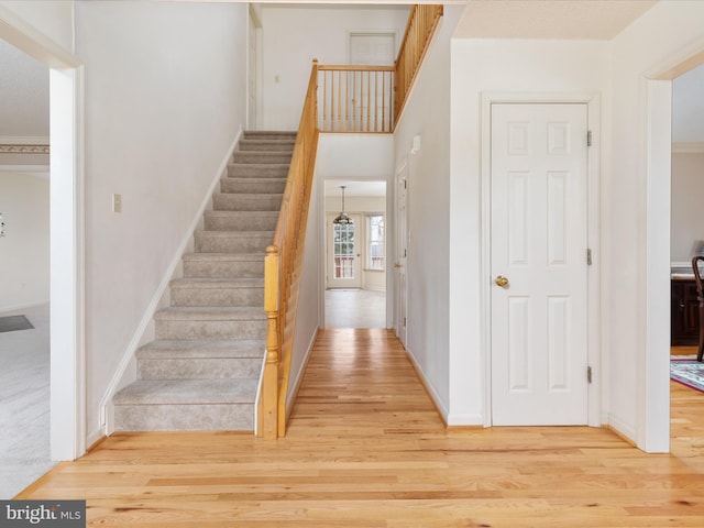 stairs with wood finished floors and baseboards