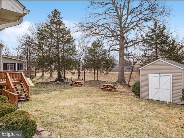 view of yard featuring stairway, a shed, a wooden deck, a sunroom, and an outdoor structure