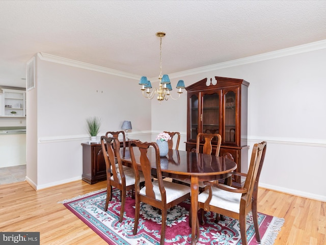 dining room with light wood-style flooring, a textured ceiling, and a chandelier