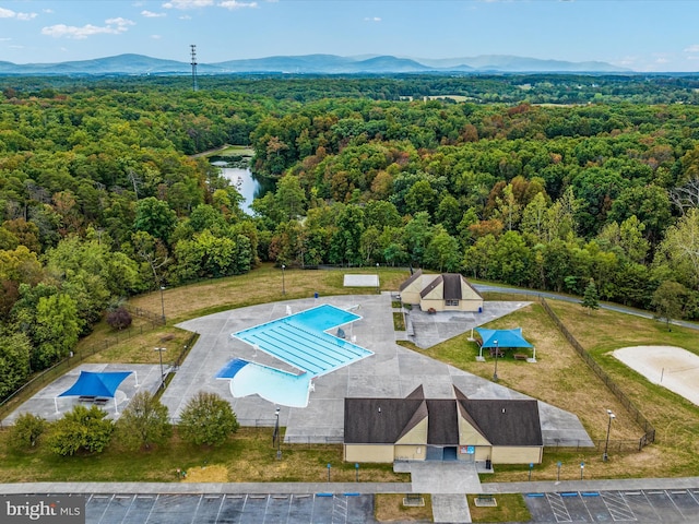 birds eye view of property with a view of trees and a water and mountain view