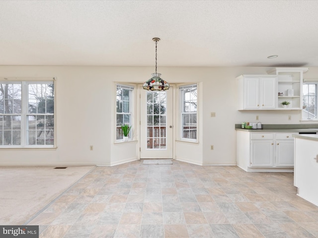 unfurnished dining area featuring baseboards and visible vents