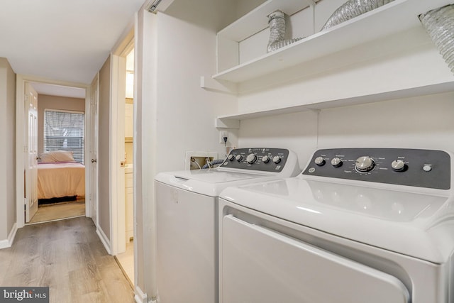 washroom with washer and clothes dryer, light wood-style flooring, and baseboards