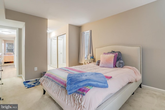 bedroom with a closet, baseboards, and carpet