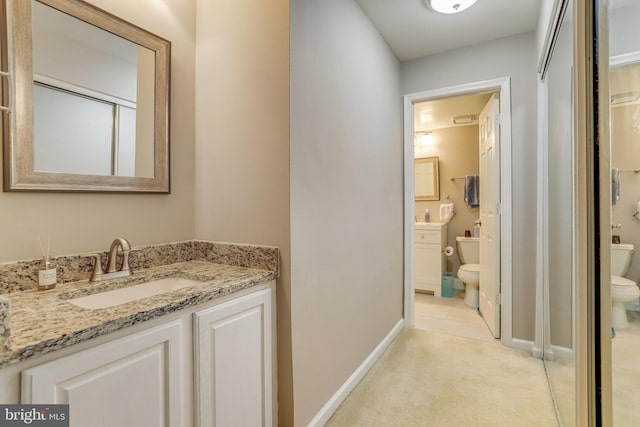 full bathroom featuring baseboards, toilet, and vanity