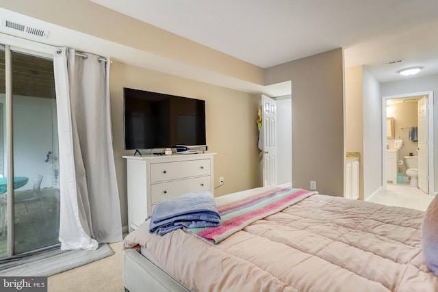 bedroom with ensuite bath, carpet, and visible vents