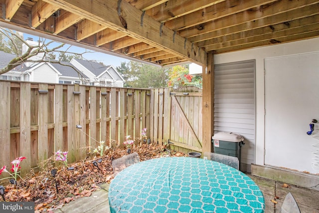 view of patio featuring outdoor dining space, a gate, and fence