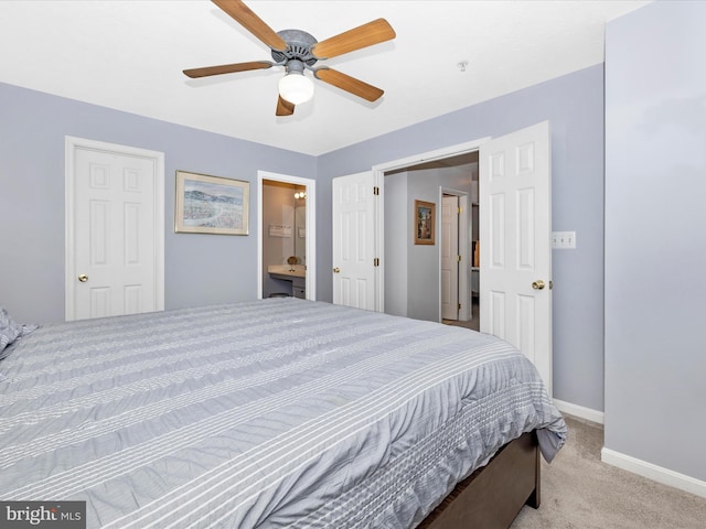 bedroom with ensuite bathroom, baseboards, ceiling fan, and carpet flooring