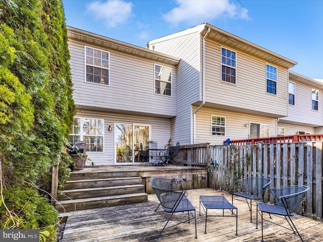 back of house featuring a deck and fence