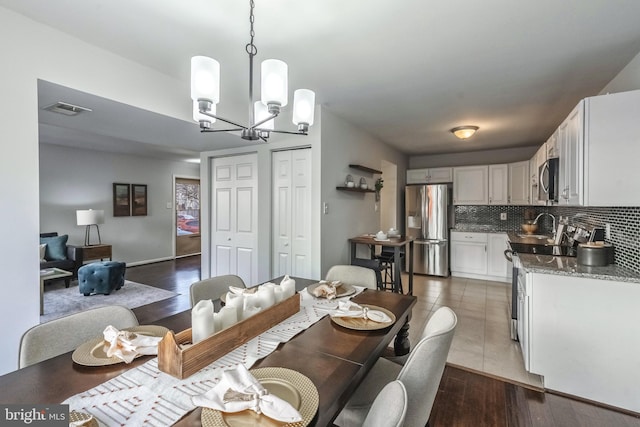 dining room featuring visible vents, a notable chandelier, and dark wood-style flooring