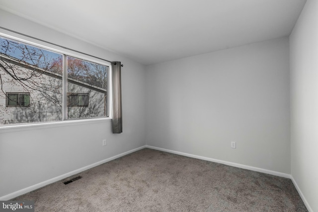 empty room featuring visible vents, baseboards, and carpet floors