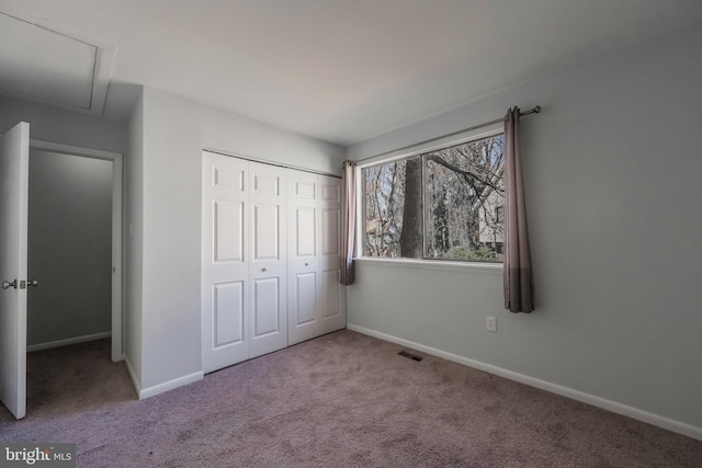 unfurnished bedroom featuring visible vents, baseboards, carpet, and a closet